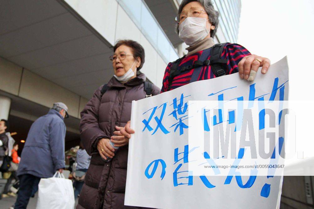 March 19th 2011 - Refugees from Futaba-cho, Fukushima - which was devastated by The 2011 Tohoku earthquake and tsunami on March 11th - arrive at Saitama Super Arena in Saitama City Japan where they will be housed for the forseeable future. Many had spent the past week in temporary shelters without adequate supplies and heat. Volunteers awaited to help foreigners who didn t understand Japanese and there were some tearful reunions. (The lady pictured wearing a mask was waiting to see her relative). As well as being destoyed by the tsunami, Futaba-cho was also just outside the nuclear exclusion zone and the refugees were glad to be abe to move away. (Photo - Yusuke Nakanishi Aflo) (aflo1090_110319_0189)