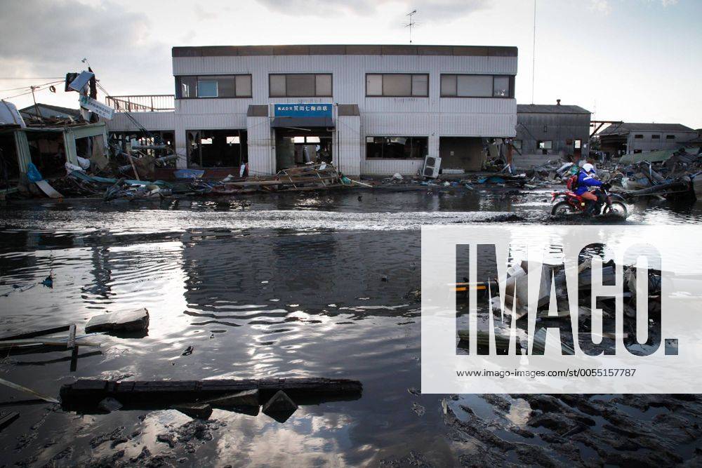 Ishonomaki, Japan - Military vehicles splash waters as they drive through the quake-devastated city of Ishinomaki, Miyagi prefecture, on Monday, March 28, 2011, as reconstruction efforts have started Ishinomaki, an industrial port some 350km northeast of Tokyo, is one of the hardest-hit areas in northeast Japan by the March 11 magnitude 9.0 earthquake and the subsequent 10-meter tsunami. Much of the town still remains submerged in muddy waters, which have hampered the efforts of people searching for missing kin and reconstruction. (uukb001079)