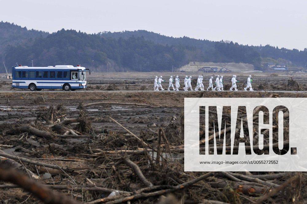 Minami - Soma, Japan - Wearing protective gear, a police search party shift through debris as they search for missing people in Minami-Soma, Fukushima Prefecture, on Friday, April 15, 2011. Southern half of the town falls within the 20km radius from the crippled Fukushima No. 1 nuclear power plant, where residents have been ordered to evacuate. More than 2,200 people have been missing in Fukushima Prefecture alone since an earthquake and tsunami hit Japan northeastern region on March 11. ( quba002239)
