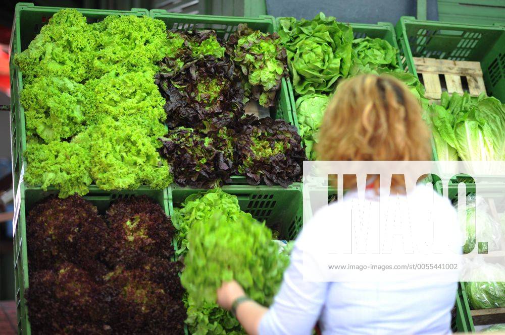 Kundin vor einem Regal mit verschiedenen Salaten in einem Supermarkt