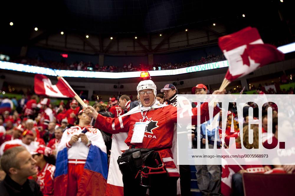 Feb. 24, 2010 - Vancouver, BC, Canada - Olympics Men s Hockey - Canadian fan wearing a helmet with a red blinking light hand out Canadian flags to other fans Quarterfinals Men s Hockey at the 2010 Winter Olympic on February 24, 2010 in Vancouver, BC. - ZUMAj89 o0 Objekte Fahne, Landesfahne Objekte