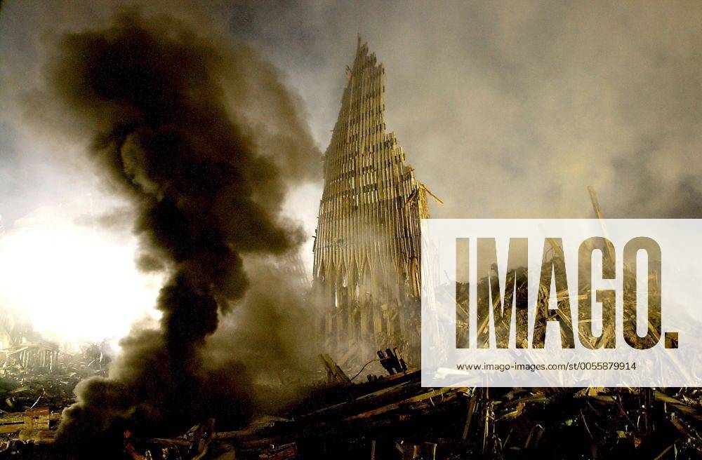 IMAGO History, Anschläge vom 11. September aus New York und Washington D.C 20 Jahre Anschläge vom 11. September: World Trade Center A cloud of smoke rises from a fuel tank fire in an area called Ground Zero in New York City as tons of wreckage still remain, including a partial standing wall of the World Trade Center, September 17, 2001, one week after the devastating attack by outside terrorists. WAX2011090115