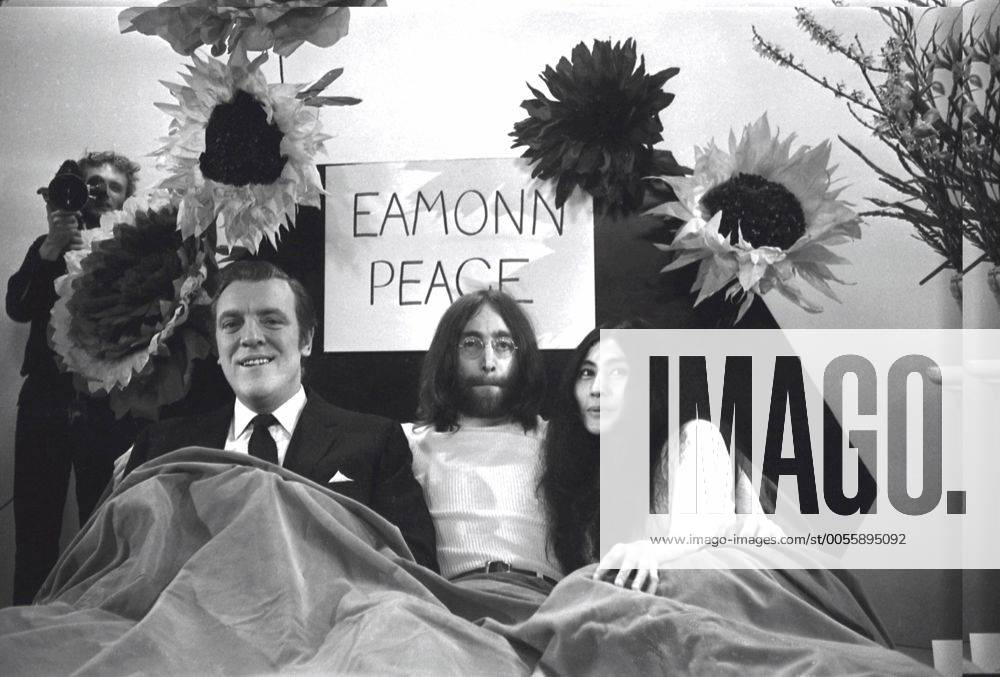 The television compete Eamonn Andrews sits in a bed with John Lennon and Yoko Ono during Thames Television prgramme Today . The couple wer interviewing Eamonn on the programme . John and Yoko returned to London from Amsterdam , where they have been in bed for a week at the Hilton Hotel , as a protest against world violence . Today , they announced they were sending the world s leaders an acorn each to plant for peace 1st April 1969 Mono Negative !AUFNAHMEDATUM GESCHÄTZT! UnitedArchives1278732