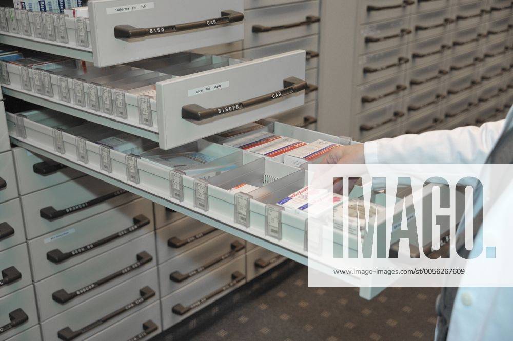 Hand nimmt Medikament aus Apothekerschrank