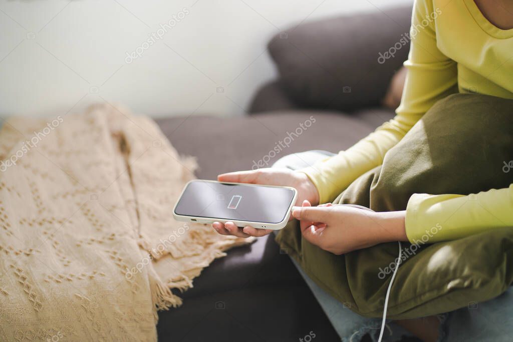 Woman hands Charging mobile phone battery with low battery. plugging a charger in a smart phone with energy bank power bank power charger Modern lifestyle energy technology concept