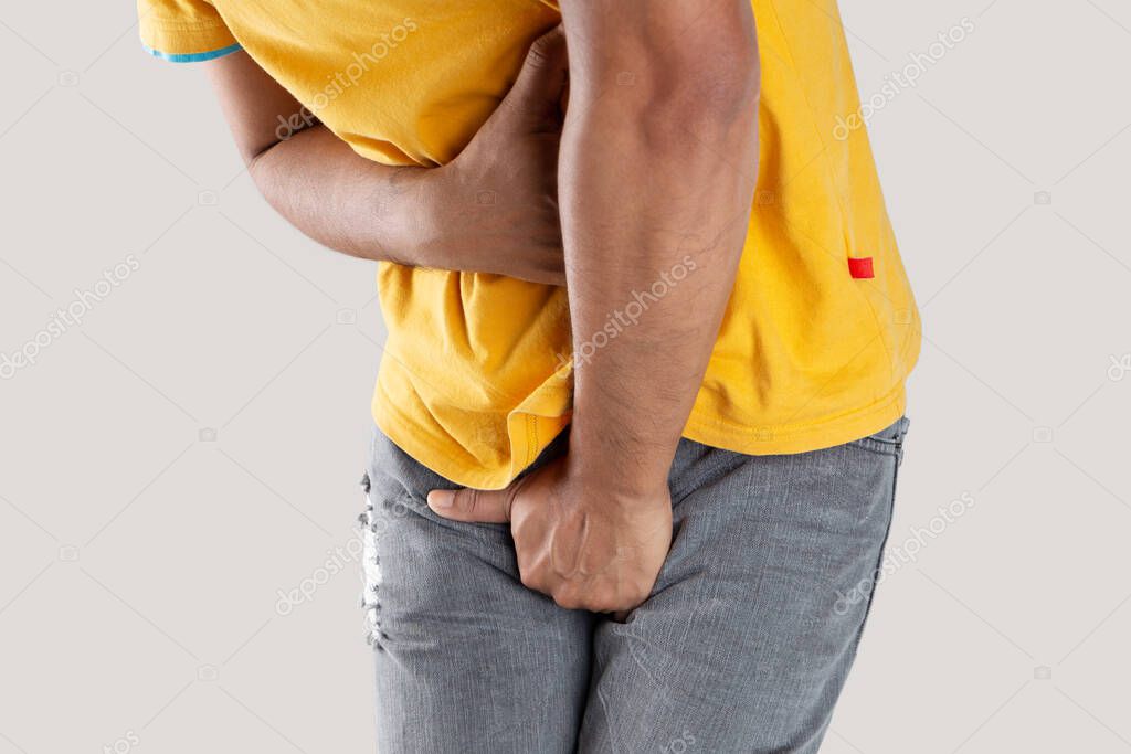 Asian man wants to pee and is holding his bladder. model released