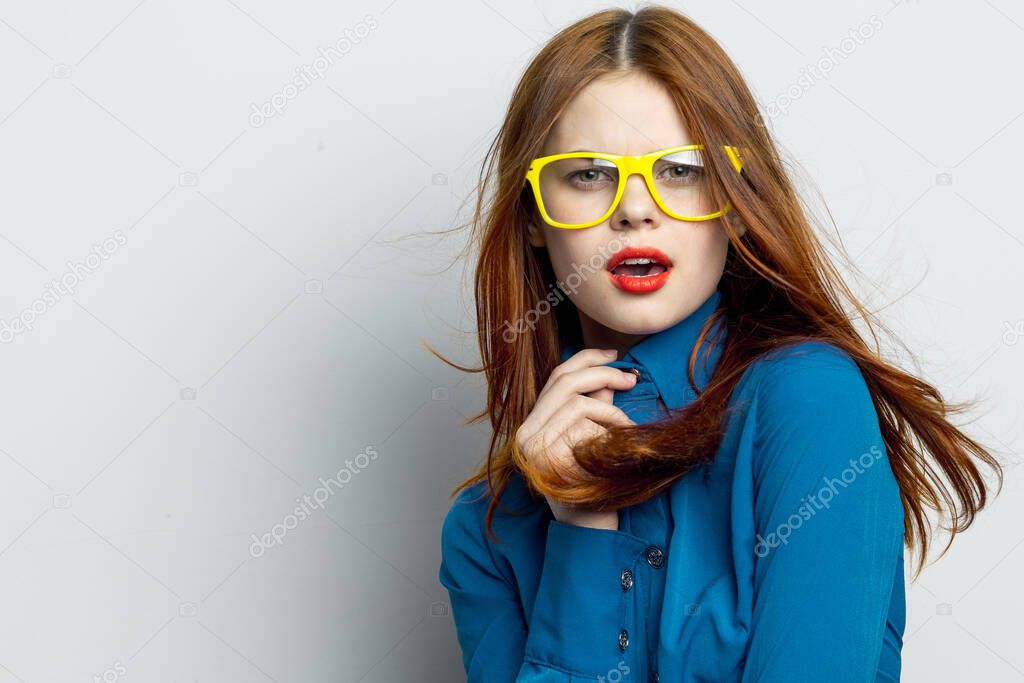 Business woman in blue shirt wearing yellow glasses emotions. High quality photo model released