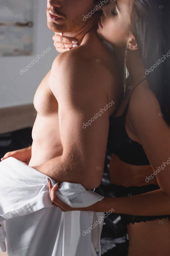 Passionate woman touching neck of shirtless boyfriend in bedroom model released