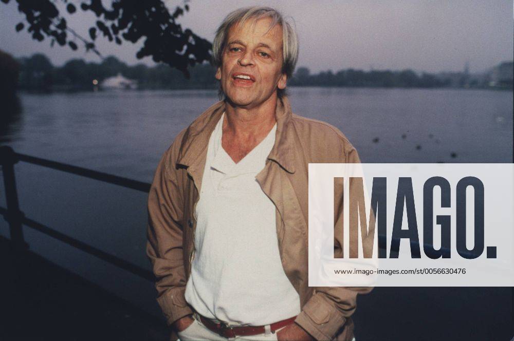 Klaus Kinski (Schauspieler) 10 85 vZ Mann TV Fernsehen Schauspiel Film Kino grauhaarig leger Jacke Hemd stehend draußen Wasser Fluß Geländer Ufer Park Baum halb quer neutral Farbnegativ Internegativ von Bild Nummer 372201