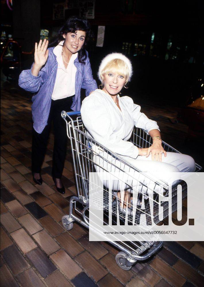 Elke Sommer (re.) mit Zoli Marki 08 84 vZ Frau Fernsehen TV Film Schauspiel Kino Szene Filmszene Spielszene leger Einkaufskorb lächelnd Gestik gestikulierend ganz hoch Laden Geschäft