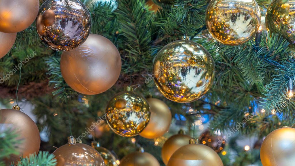 Traditional artificial Christmas tree with Christmas toy, ball and glowing colorful lights in background. Xmas concepts. Close-up of Christmas tree. Defocused background.
