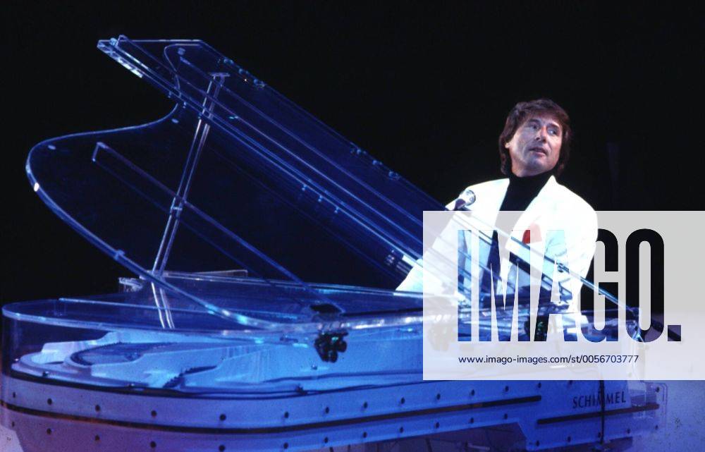 Udo Jürgens (Schlagersänger, Pianist) 05 88 vZ Musik Gesang Schlager Pianist Komponist kurzhaarig dunkelhaarig seriös Jackett Hemd sitzend spielend singend Instrument Piano Klavier Auftritt Bühne Mikrophon halb quer