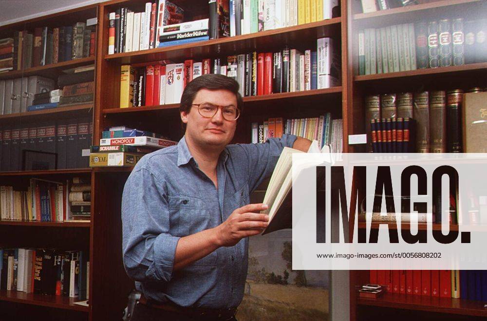 Sigmund Gottlieb 09 89 ru Mann Journalismus Moderation News Brille dunkelhaarig leger Homestory quer halb stehend Wohnzimmer Buch lächelnd