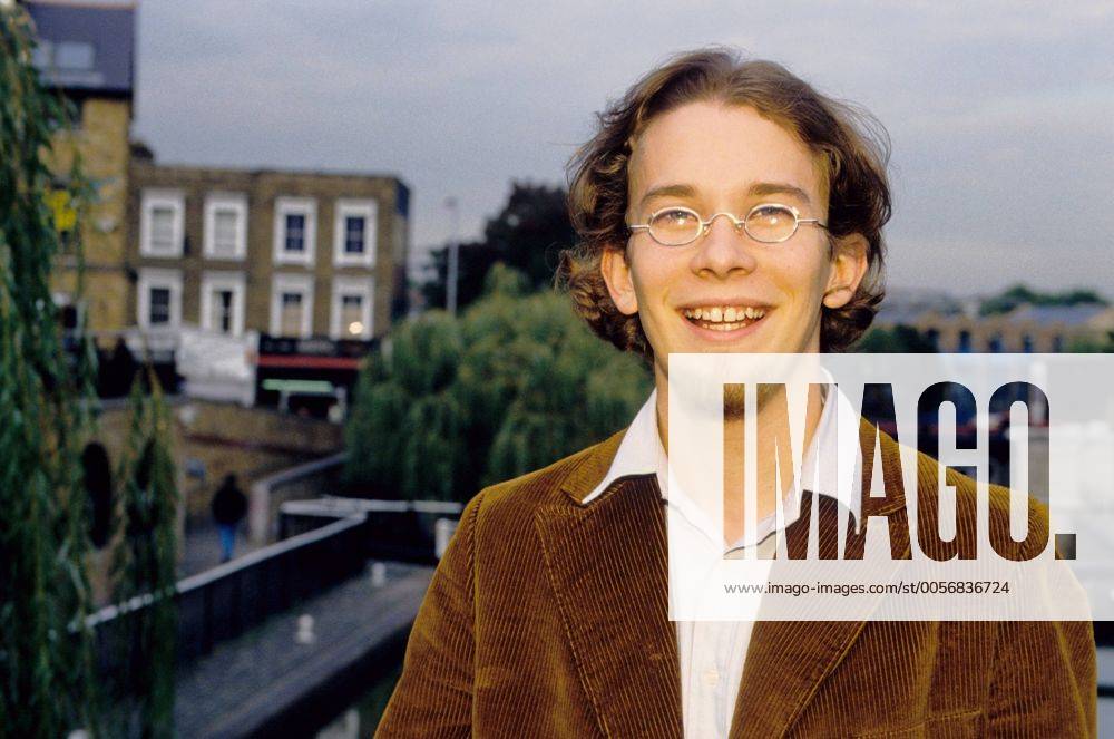 Christian Ulmen (VJ bei MTV) 10 96 sd Mann TV Fernsehen Moderation Musik VJ dunkelhaarig leger Hemd Jackett Brille Bart draußen stehend Stadtansicht Gebäude Haus halb quer lächelnd