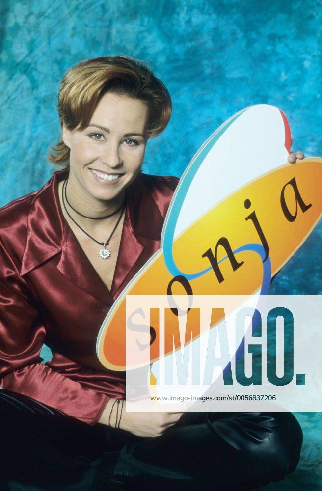 Sonja Zietlow (TV-Moderatorin) 01 97 her Frau TV Fernsehen Moderation Talkshow blond kurzhaarig leger Bluse rot Dekollete Schmuck Kette Armband sitzend Boden Schild haltend Logo Sonja lächelnd halb hoch