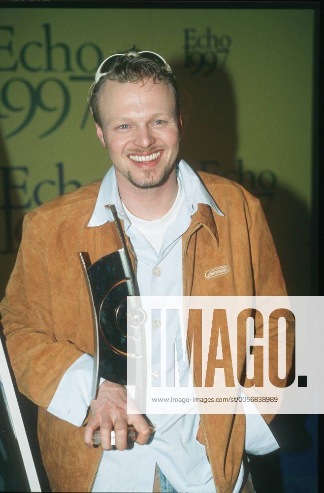 Echo Verleihung 1997 in Hamburg Stefan Raab (Musiker, Sänger) 02 97 her Mann TV Moderation Musik VIVA Unterhaltung dunkelhaarig leger Jeans Hemd Bart Lederjacke Sonnenbrille Preis Echo 1997 Trophäe stehend ganz hoch lächelnd