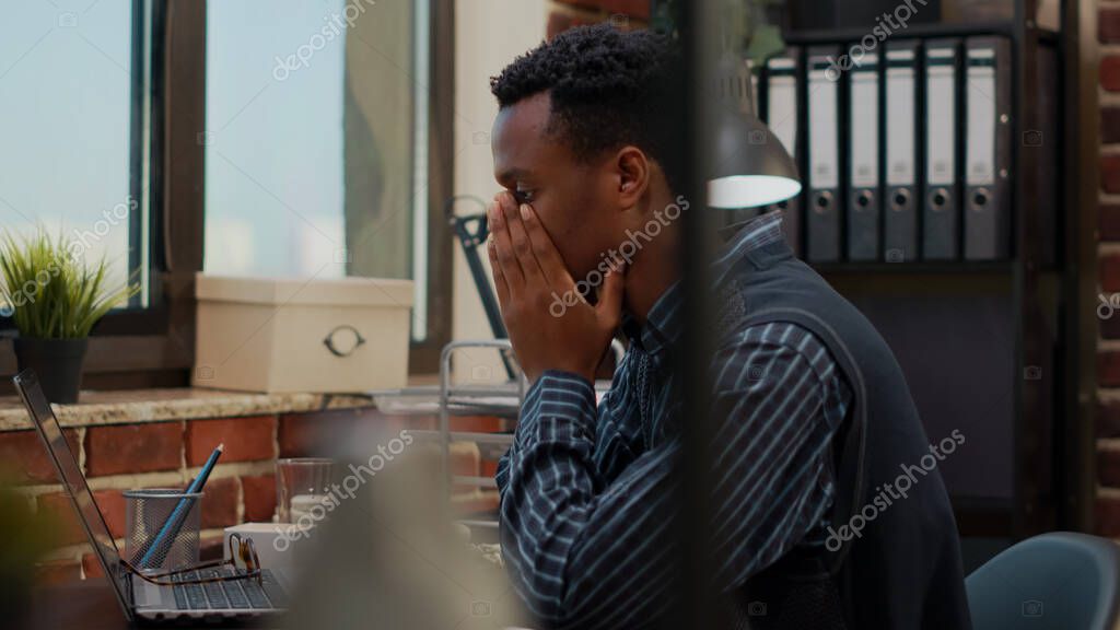 Anxious worker finging put bad news about business project in office. Company accountant worrying about work failure, planning financial report under pressure on laptop. Frustrated man model released