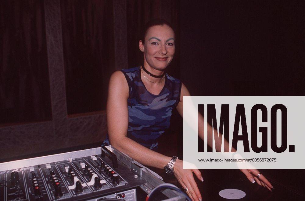 Marusha (Diskjockey) 05 98 her Musik Pop Techno DJ Frau leger langhaarig Diskjockey Pferdeschwanz leger Shirt Schmuck Halsband Augenbraue grün stehend Mischpult Apparat halb quer lächelnd