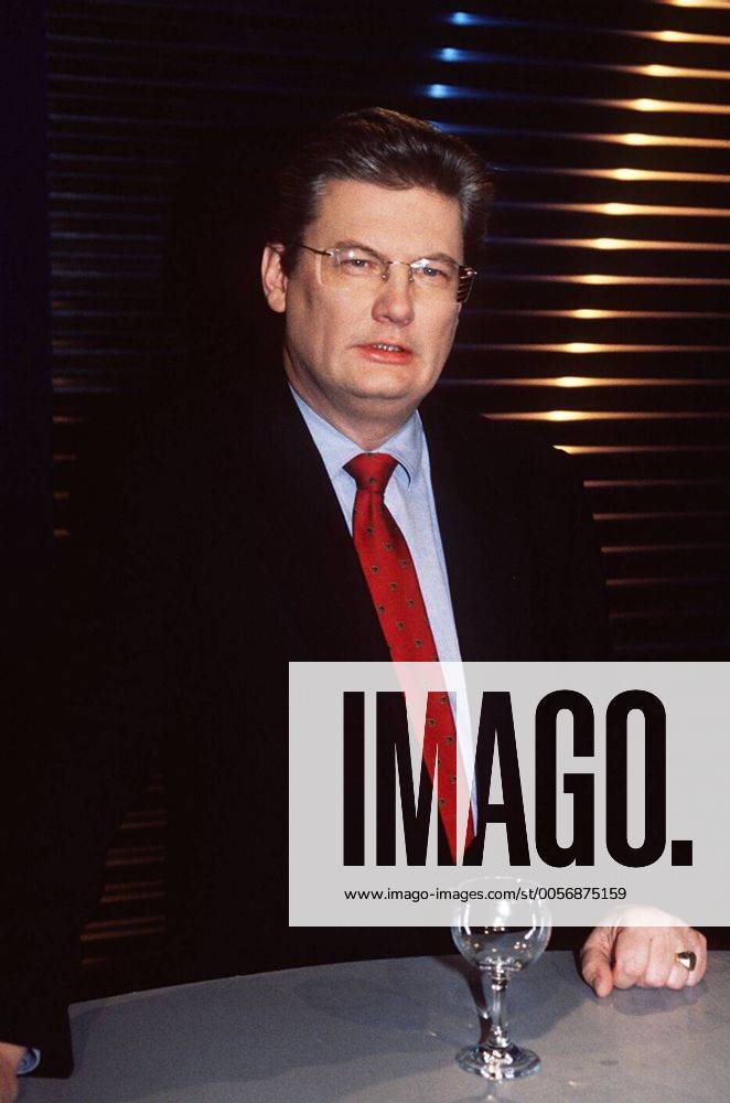 Sigmund Gottlieb (Journalist) 01 98 pu Mann Journalismus TV Fernsehen Moderation dunkelhaarig seriös Hemd Jackett Krawatte stehend Tisch Glas Studio Dekoration Kulisse halb hoch neutral Brille