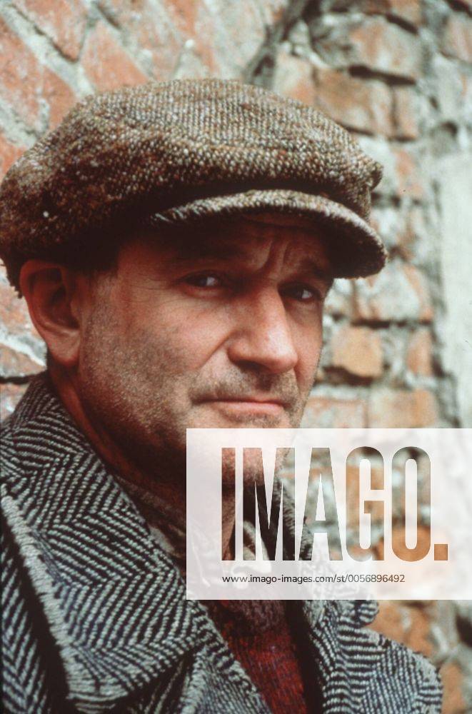 Robin Williams in Jakob der Lügner 08 99 teu Mann USA Amerika dunkelhaarig Schauspiel Kino Film Szene Filmszene Verkleidung Kostüm Mantel Fischgrätmuster Hemd alt Pullunder Baskenmütze stehend draußen Mauer Backstein kaputt Dreitagebart Portrait hoch ratlos traurig müde