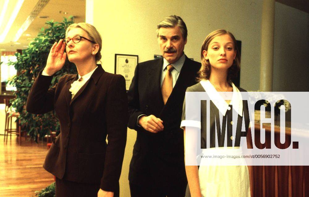 Vertrauen ist alles (ZDF) v.l.: S. Vester, P. Simonischek, A. M. Lara 10 99 ker TV Fernsehen Film Schauspiel Saskia Peter Alexandra Maria Szene Szenenfoto seriös Anzug Krawatte Kostüm Brille Hochsteckfrisur Schürze Uniform stehend Hotel Rezeption Blume halb quer Gespräch skeptisch nachdenklich gelangweilt