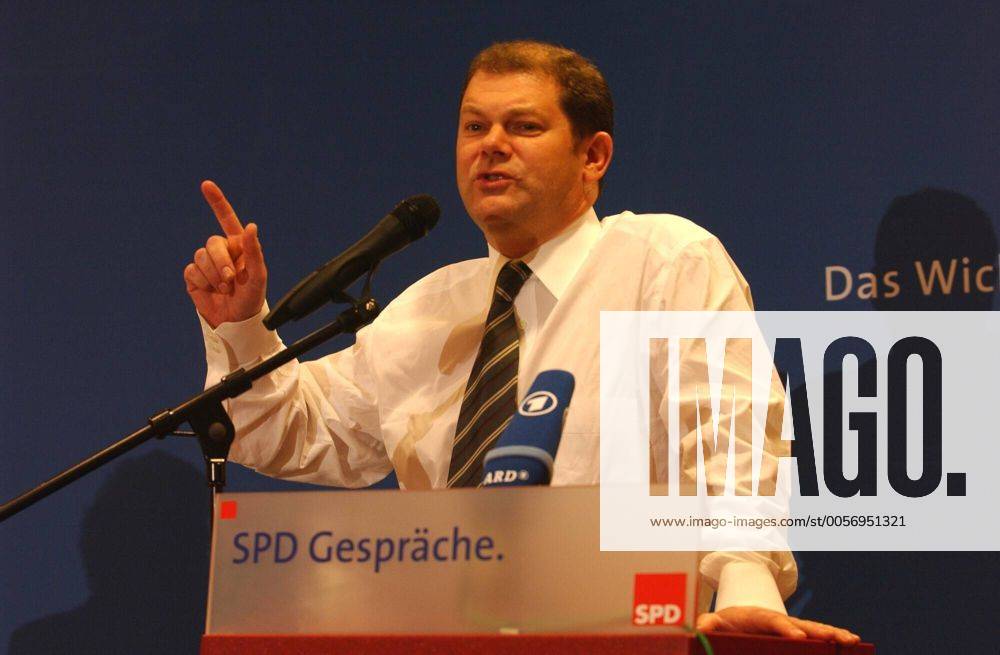 Olaf Scholz (Politiker) 02 04 wow Mann Politik Politiker Partei SPD Generalsekretär Rücktritt Bekanntgabe Ankündigung angekündigt am 6. Februar 2004 dunkelhaarig kurzhaarig leger Hemd Krawatte halb quer stehend Pult Rednerpult lächelnd Schild SPD Gespräche Mikrofon sprechend Halbprofil Gestik gestikulierend Zeigefinger erhoben erhobener Fototermin am 05.02.2004 in Gütersloh