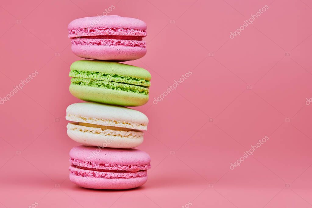 Macaroons on pink background. Colorful small cookie from ground almonds and coconut. Popular confectionery. Tasty snack food for take away, copy space