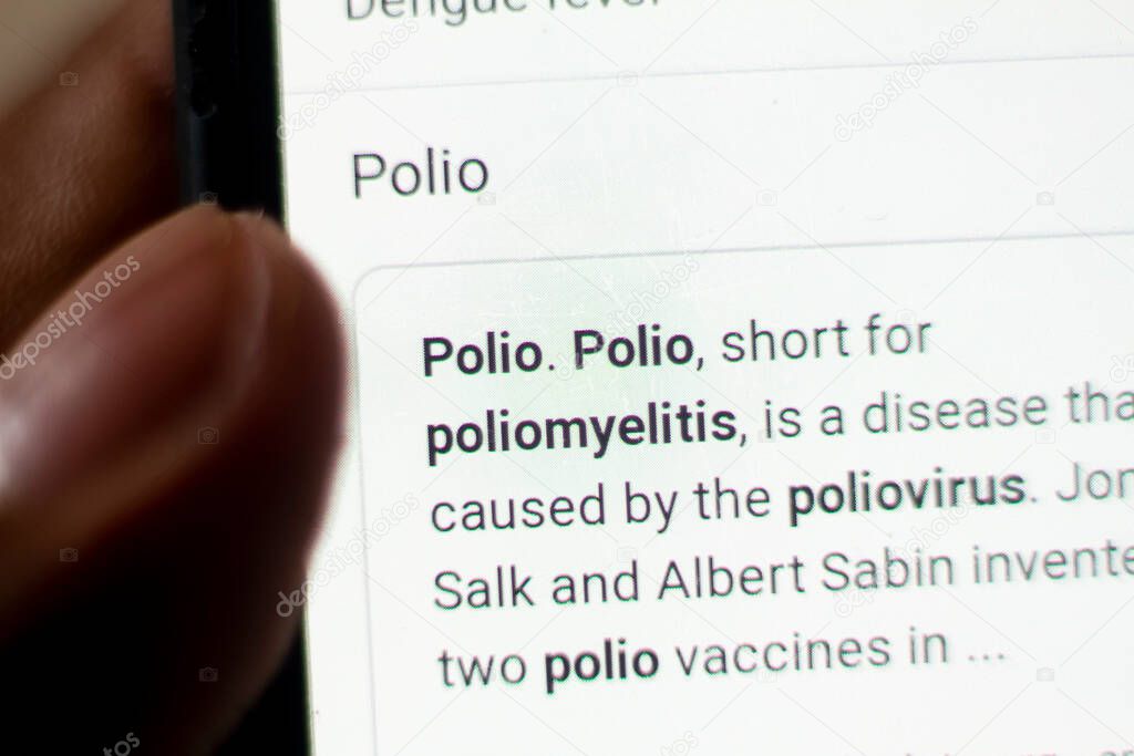 Polio News on the phone.Mobile phone in hands. selective focus and chromatic aberration effects.