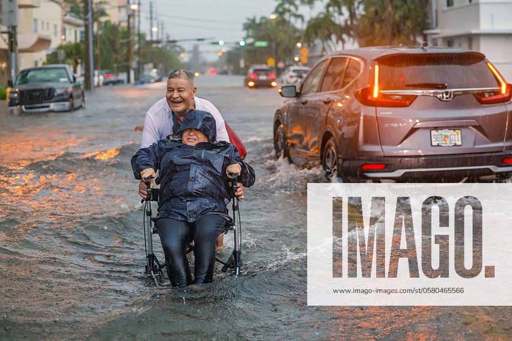 Victor Corone, 66, pushes his wife Maria Diaz, 64, in a wheelchair through more than a foot of flood water on 84th street in Miami Beach on Wednesday, June 12, 2024. Diaz had a doctor s appointment, and they had to ditch the car in the parking lot on Collins Ave and walk more than 20 minutes to get home. - ZUMAm67_ 20240613_zaf_m67_004