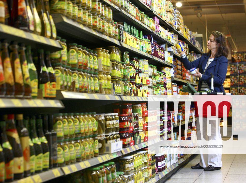 Lebensmittelabteilung, Frau kauft ein. Gemüsekonserven, Dosen. Grosser Supermarkt, Selbstbedienung. Deutschland, Europa.