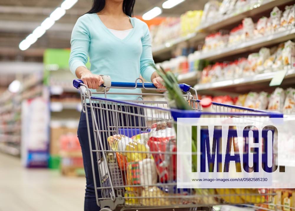Consumerism and people concept - woman with shopping cart or trolley buying food at grocery store or supermarket. woman with food in shopping cart at supermarket ,model released, Symbolfoto; Konsumismus und Personen Konzept Frau mit Einkaufen Karren Oder Rollwagen kaufend Lebensmittel im grocery Ladengeschaeft Oder Supermarkt Frau mit Lebensmittel in Einkaufen Karren im Supermarkt ,model released, Symbolfoto ING_33594_206341