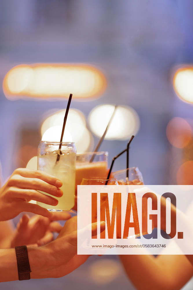 Close-up of female and male hands holding glasses of lemonade. Men and women clink cups. Carbonated drinks with ice cubes and straws. Close-up of female and male hands holding glasses of lemonade. Men and women clink cups. Carbonated drinks with ice cubes and straws. A party or a meeting of friends.