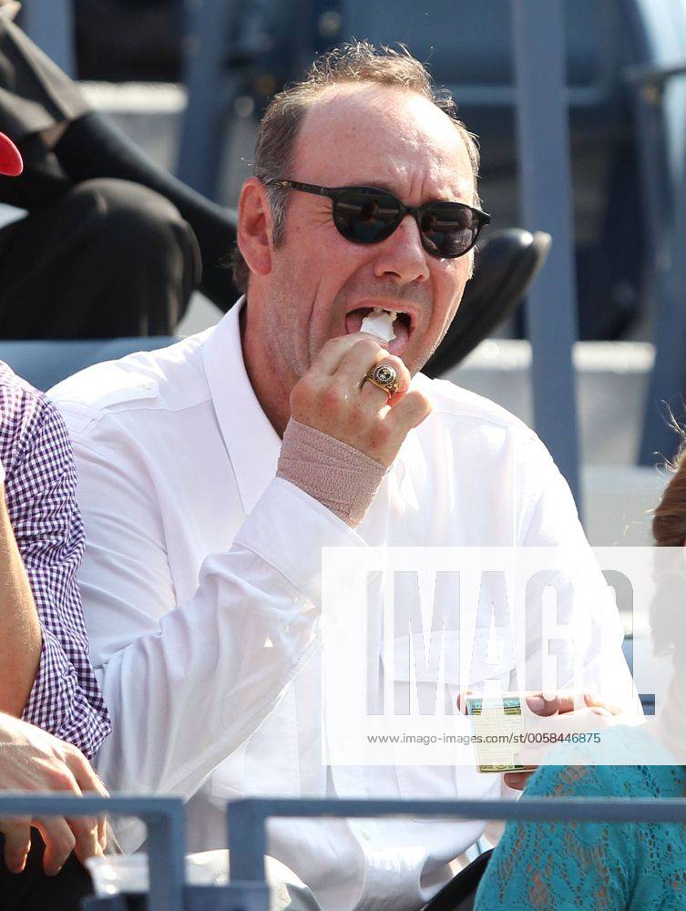US Open 2012, USTA Billie Jean King National Tennis Center, Flushing Meadows, New York, ITF Grand Slam Tennis Tournament,Schauspieler Kevin Spacey mit Eiscreme sitzt als Zuschauer auf der Tribuene, Einzelbild,Halbkoerper, Hochformat,Feature,VIP,Ehrengast,