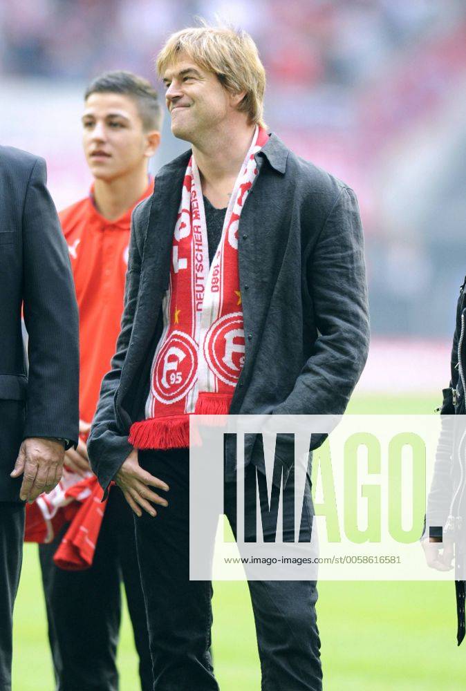 Fussball-Bundesliga, Deutschland, Herren, Saison 2012 2013, 8. Spieltag, ESPRIT-Arena Düsseldorf: Fortuna Düsseldorf (rot) - FC Bayern München (weiss) 0:5; Sänger Campino von den Toten Hosen grinst verschmitzt.