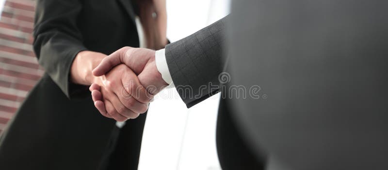 Close up of businessman and businesswoman shaking hands, Successful business people handshaking after perfect deal.