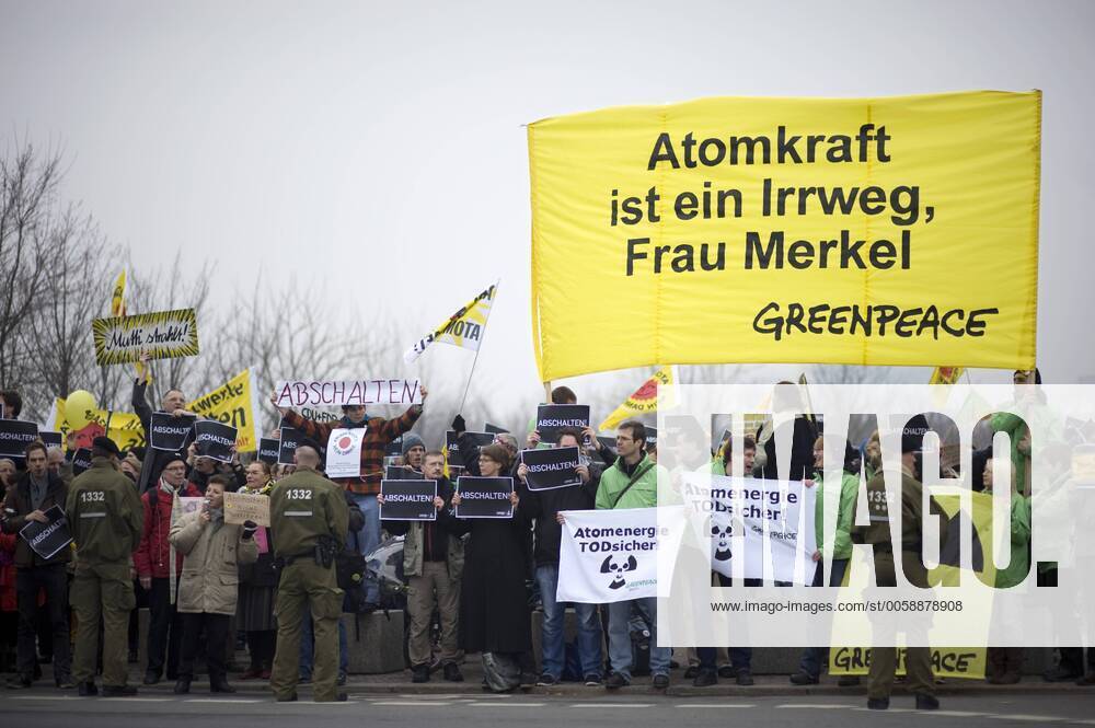 Mahnwache Atomkraft abschalten DEU, Deutschland, Germany, Berlin, 15.03.2011 Demonstranten mit Plakat Atomkraft ist ein Irrweg Frau Merkel von Greenpeace bei der Kundgebung und Mahnwache fuer den Atomausstieg unter dem Motto Atomkraft abschalten, Atomausstieg jetzt vor dem Bundeskanzleramt in Berlin. Die Kundgebung organisiert von Campact und anderen Antiatominitiativen fordert die Abschaltung aller Atomkraftwerke und erinnert an die Auswirkungen der Naturkatastrophe in Japan und das Desaster der japanischen Atomkraftwerke. Kundgebung gegen die Atompolitik der schwarz-gelben Koalition und der Bundesregierung. Atomkraft Nein Danke, Atomkraftgegner, Antiatombewegung, Anti-Atom-Demo, Antiatom, Anti-Atomkraft, Atomkraft, Atomkraftwerke, Anti-Atom, Anti-Atom-Bewegung, Atomenergie, Atompolitik, Anti, Atomenergie, Demonstration, demonstrieren, Demonstrant, Demonstranten, Atomkraftgegener, Kern