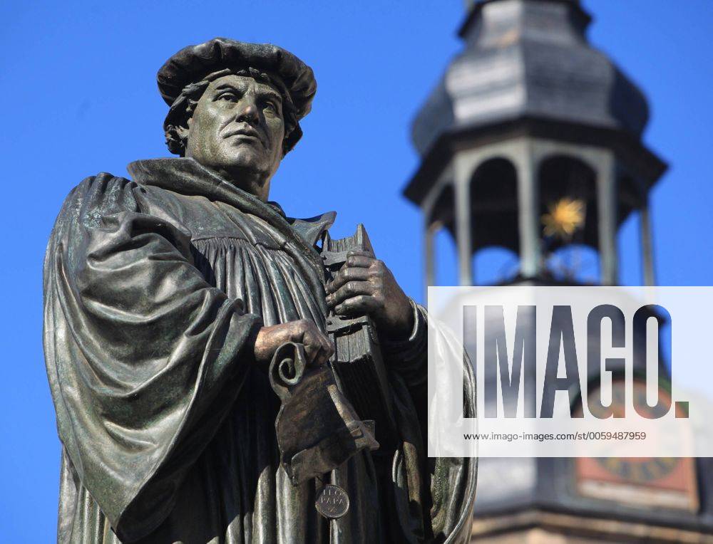 Denkmal des Reformators Martin Luther auf dem Marktplatz in Eisleben (Sachsen-Anhalt) mit dem Turm der St. Andreaskirche im Hintergrund am 23.9.2009. Das Denmal, das 1883 von dem Berliner Bildhauer Rudolf Siemerin errichtet wurde, zeigt Luther, wie er die Bannbulle des Papstes zerreißt. In Eisleben wurde der Reformator am 10.11.1483 geboren; am 18.2.1546 starb er hier. In der Andreaskirche hielt er seine letzten Predigten. Der Überlieferung nach schlug Martin Luther am 31. Oktober 1517 seine 95 Thesen gegen den Ablasshandel der Kirche an die Tür der Wittenberger Schlosskirche. Das Ereignis gilt als Beginn der Kirchenreformation. Der 31. Oktober wird deshalb von evangelischen Christen als Reformationstag gefeiert. 2017 jährt sich der legendäre Thesenanschlag Martin Luthers an der Schlosskirche zum 500. Mal. Reformationstag am 31. Oktober 325831