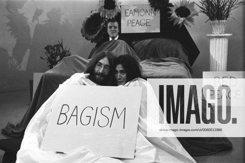 The television compete Eamonn Andrews sits in a bed during Thames Television prgramme Today . John Lennon and his wife Yoko One cuddle up together in a bag . The couple wer interviewing Eamonn on the programme . John and Yoko returned to London from Amsterdam , where they have been in bed for a week at the Hilton Hotel , as a protest against world violence . Today , they announced they were sending the world s leaders an acorn each to plant for peace 1st April 1969, Fernsehen, Fernsehshow, Fernsehstar, Fernseher UnitedArchives00703244