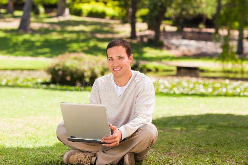 Man working on his laptop in the park, Man working on his laptop in the park on the grass model released