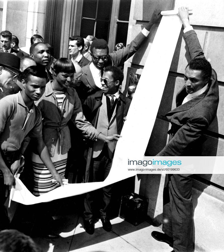 Solidarity meeting at the US Embassy in Paris of Americans , , who, unlike Burt Lancaster cannot go back to the US for a day to take part in the March on Washington.With the Secretary & the long roll of signatures, we recognize James Baldwin,William Marshall, May Mercer & Slim Memphis.21st August 1963 UnitedArchives00957762