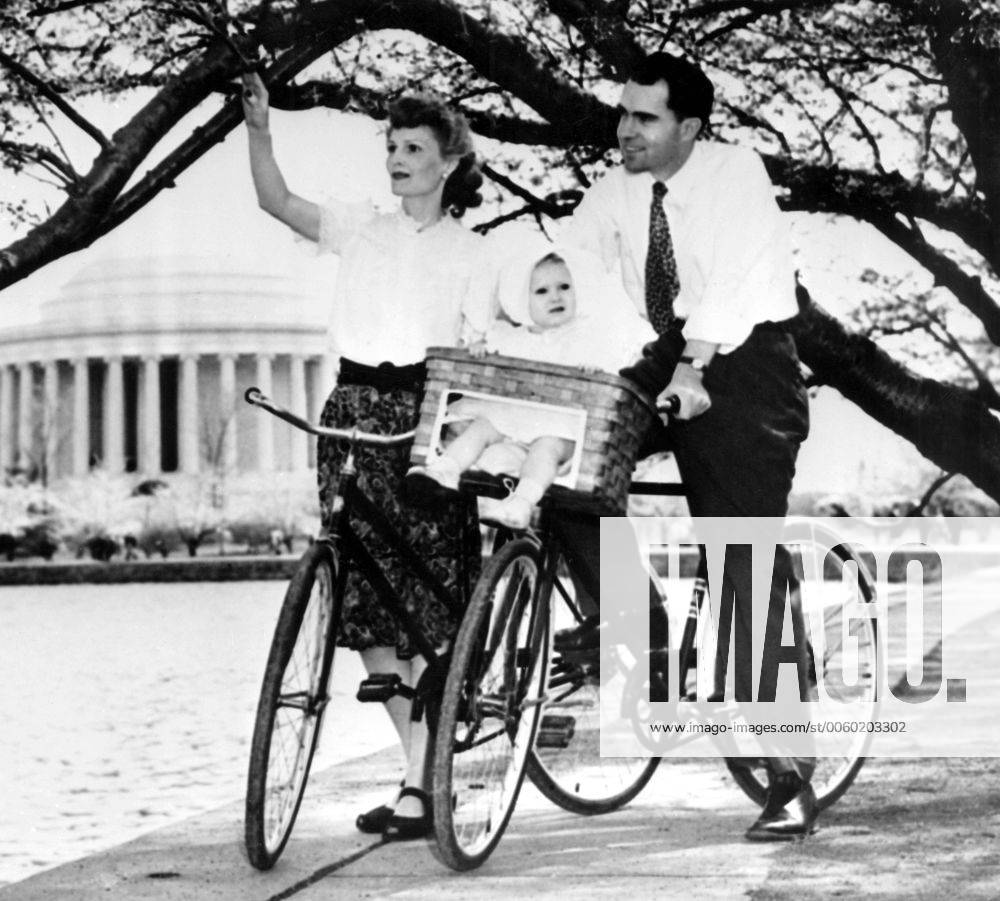 With 13 month old daughter Patricia riding in a specially fitted bicycle basket, Richard Nixon of California and Mrs Nixon pause here on 13th April 1947 to admire the cherry blossoms 28th July 1960 UnitedArchives01006846