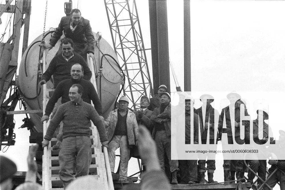 Vor 50 Jahren, am 24. Oktober 1963, wurden in einem Stollen der Eisenerzgrube Lengede-Broistedt bei Peine 129 Bergleute in 60 m Tiefe verschüttet. Die Rettung von 11 eingeschlossenen Bergleuten nach 14 Tagen ging als Wunder von Lengede in die Geschichte ein, Die Rettungsaktion Barbecke ist beendet, drei eingeschlossene Bergleute werden am 1. November 1963 aus 82 Metern Tiefe gerettet, hier steigen sie glücklich eine Treppe herunter aus einer Druckkammer, in der sie nach ihrer Rettung mit der Dahlbuschbombe dekomprimiert wurden, beobachtet von den an der Rettungsbohrung beteiligten Arbeitern, Grubenunglück und Wunder von Lengede im Oktober November 1963, SW-Aufnahme, 01.11.1963. Grubenunglück von Lengede, Alter Mann, Schacht Mathilde, Wunder von Lengede, Bergmann, Kumpel, Bergleute, Wassereinbruch, Grube, Erzbergwerk, Bergwerk, Unter Tage, Rettung, Dahlbuschbombe, Rettungsbohrung