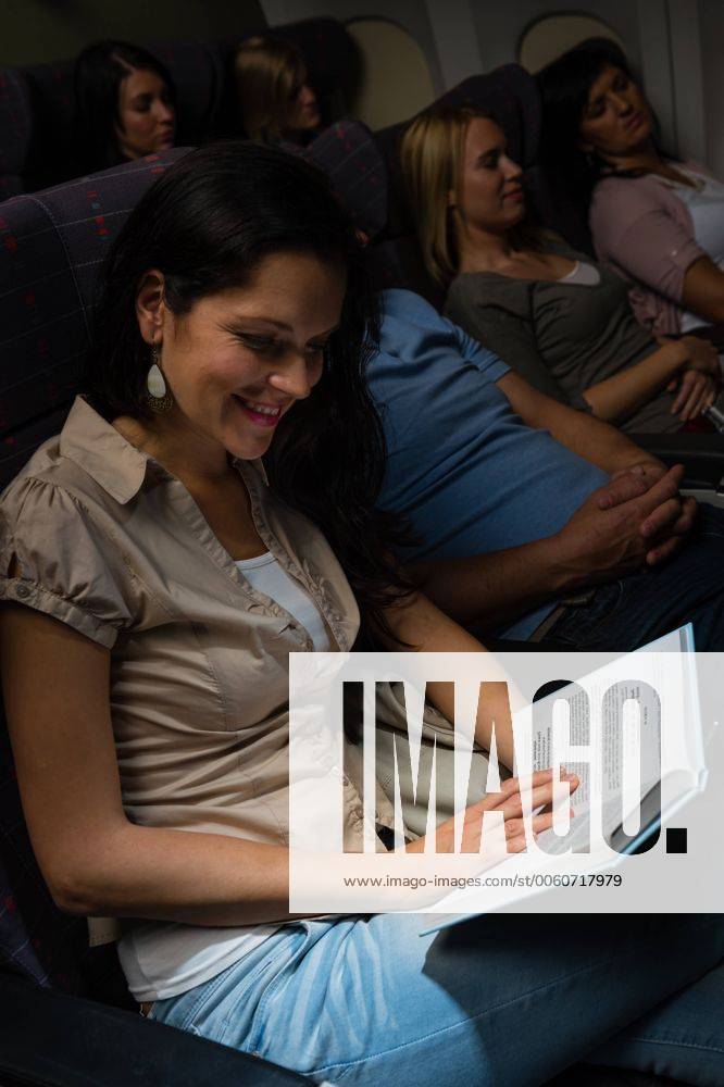 Young woman read book airplane night flight cabin leisure travel CTKPhotoF201311140616101 028_032_181013