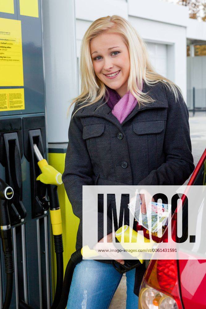 Eine junge Frau Tankbenzin auf einer Tankstelle. Die Kosten für das Auto werden wegen der Benzinpreise immer teurer McPBBO McPBBO