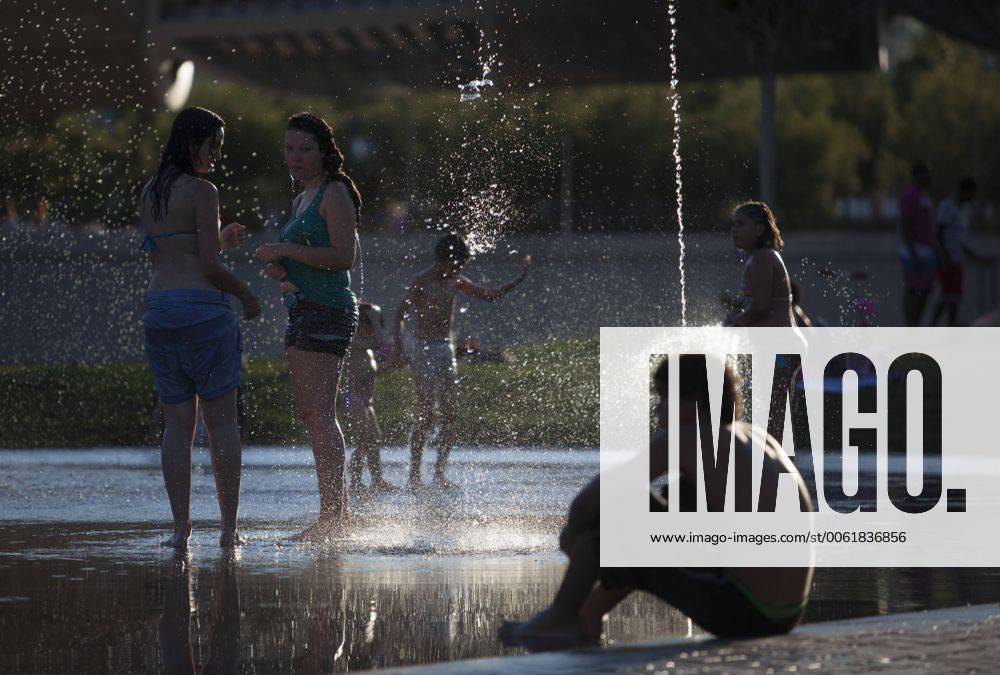 People enjoy in a font on the Manzanares riverside. After of a rare cold weather finally arrived the heat to Madrid city. Spain.