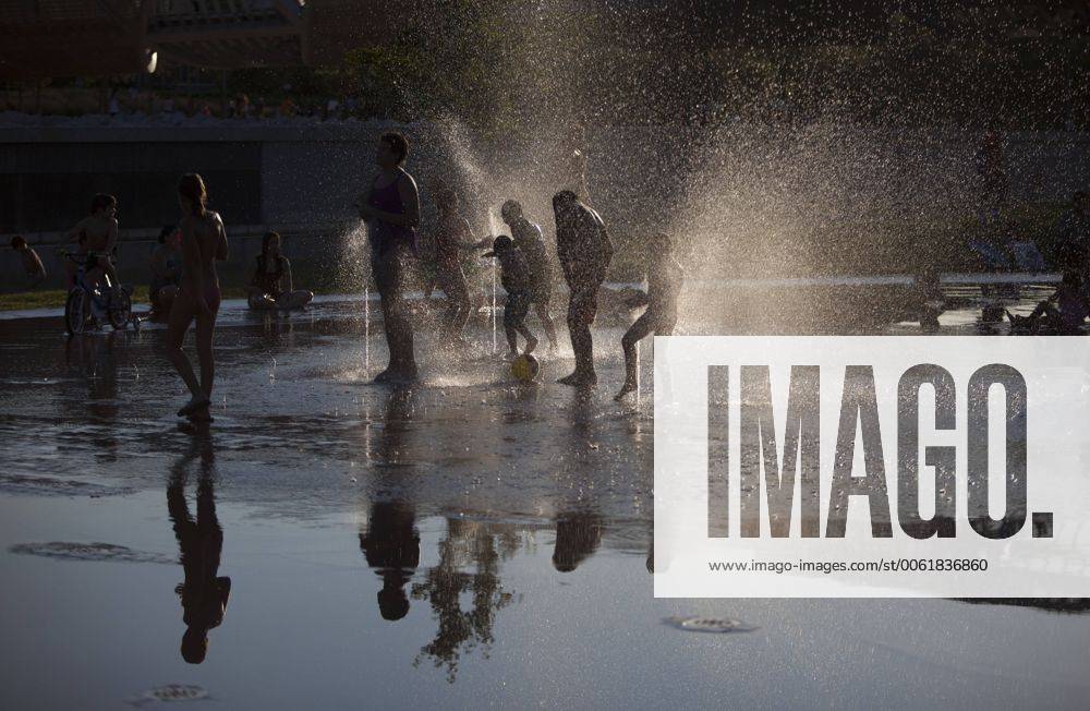 People enjoy in a font on the Manzanares riverside. After of a rare cold weather finally arrived the heat to Madrid city. Spain.