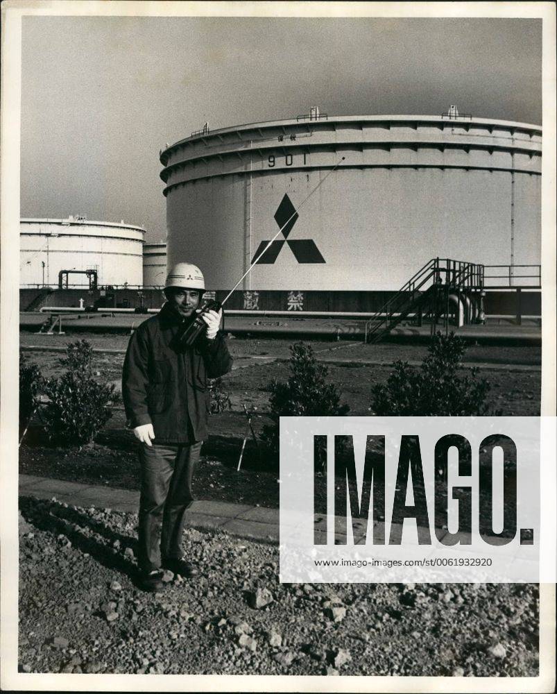 Apr. 04, 1979 - Mitsubishi Oil Co. Kawasaki Refinery, Kawasaki Japan: The Kawasaki Refinery Stores its crude oil on Ohgishima Island where they have hour 94,000 kiloleter product storage tanks, Photo shows A Mitsubishi security employee in fron of one of the large crude oil storage tanks on ohgishima island. - ZUMAk09