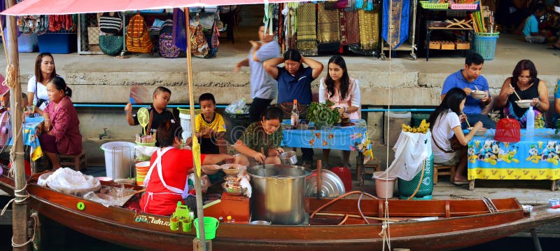 Damnoen Saduak Floating Market, A woman sells food from a boat in the eatery on Damnoen Saduak Floating Market in Thailand.
