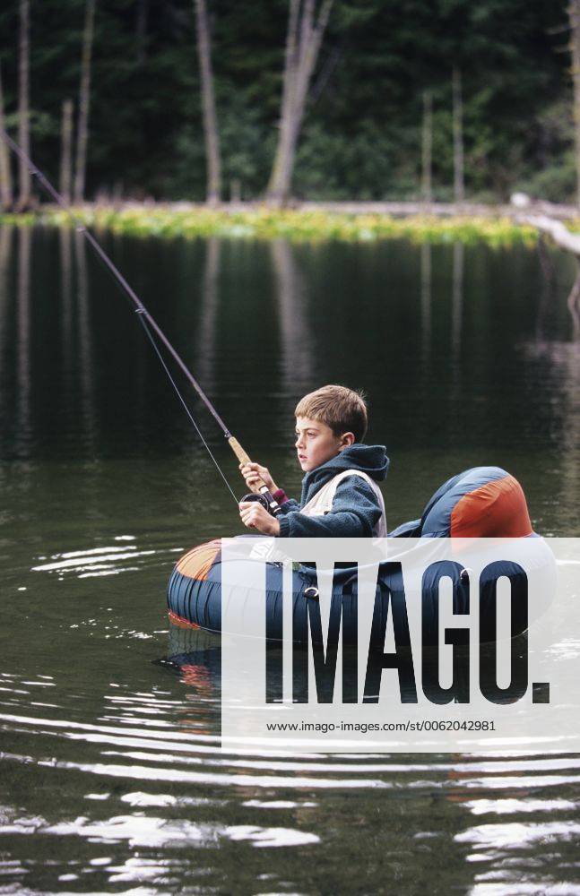 Boy fly fishing from float tube in small lake, British Columbia, Canada. acp02125 ChrisxCheadle