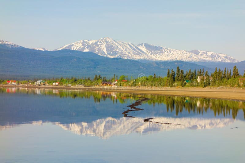 Beautiful marsh lake in the yukon territories, Snow-capped mountains reflected in still water near whitehorse